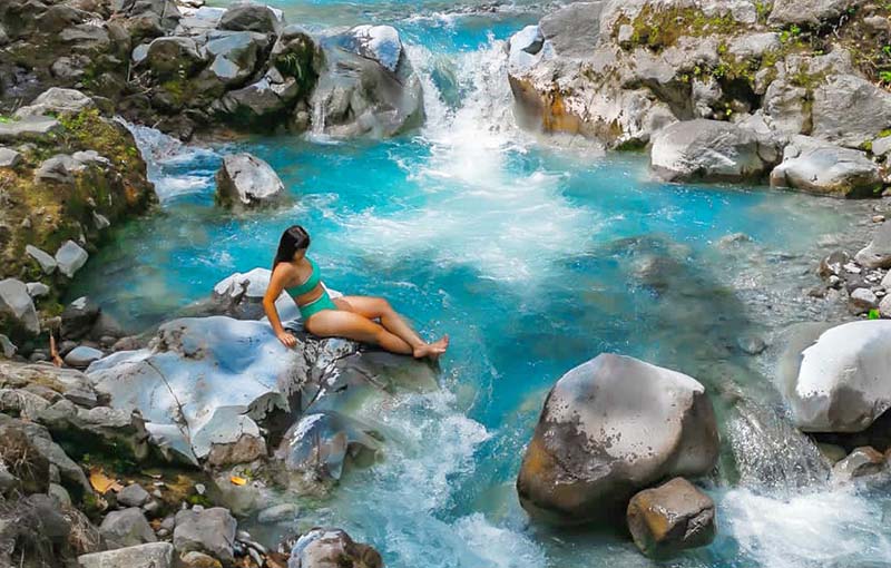 A girl in the blue morpho waterfall